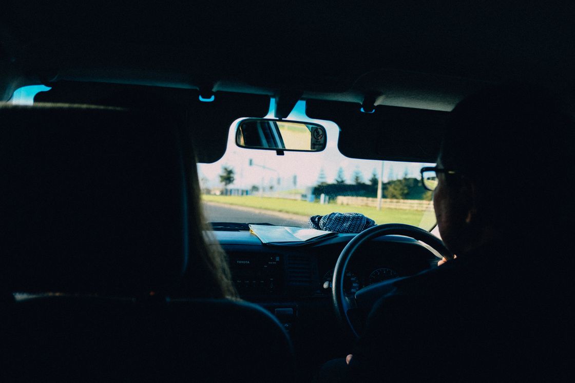 View from the driver's seat of a right-hand-drive car, hands on the wheel with the road ahead